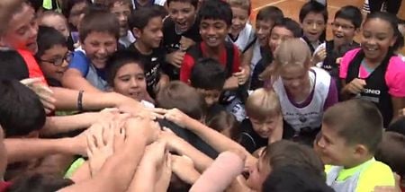 VIDEO: NBA point guard is absolutely mobbed by hundreds of kids after sinking half court shot